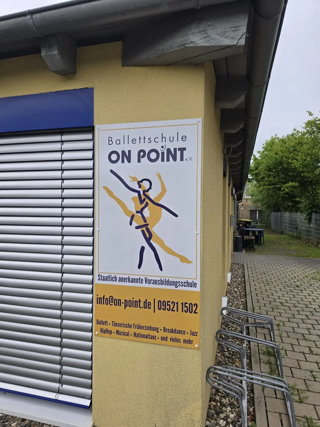 Eingangsschild der Ballettschule On Point mit Kursübersicht