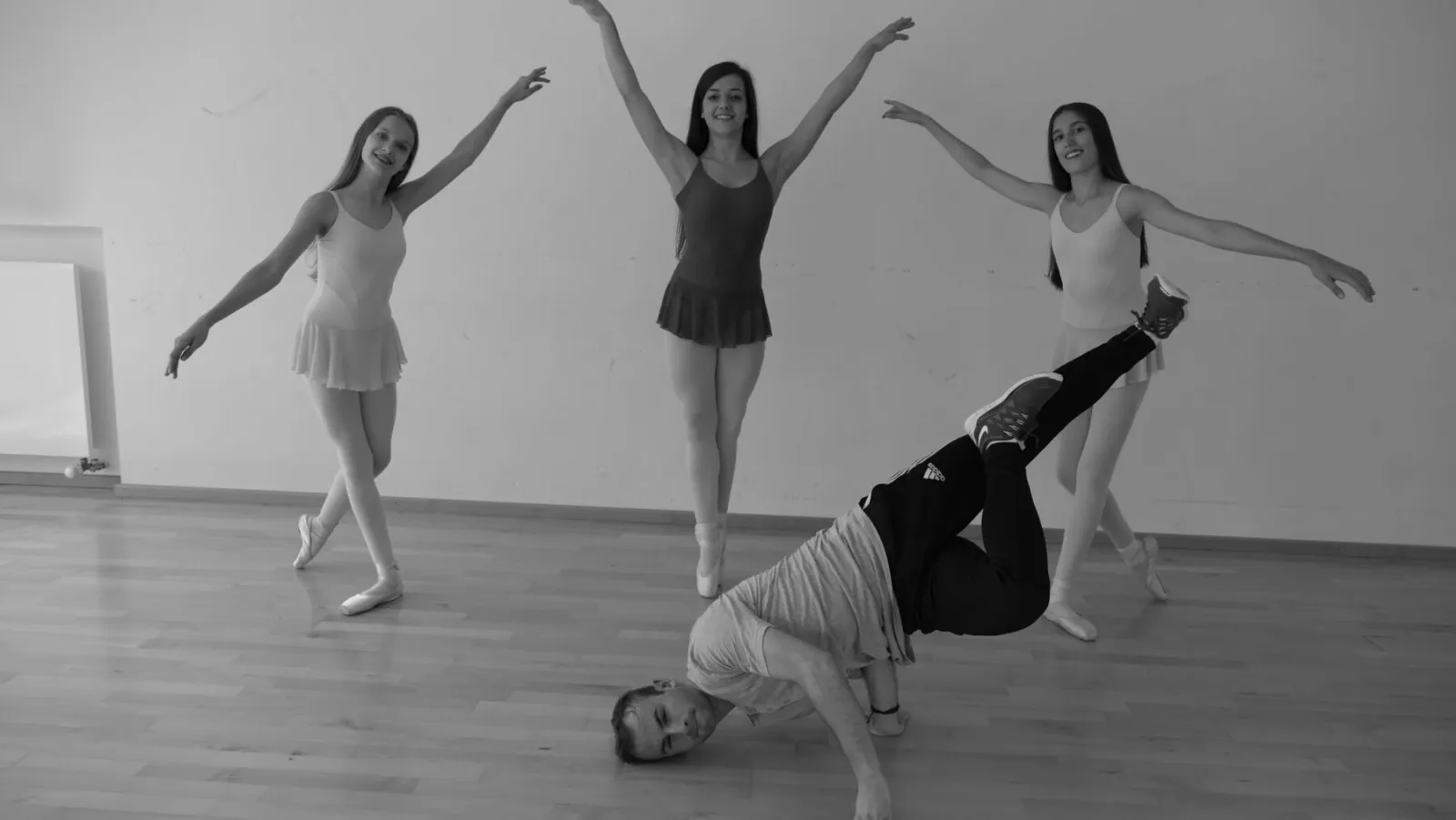Drei Tänzerinnen und Breakdancer im Studio